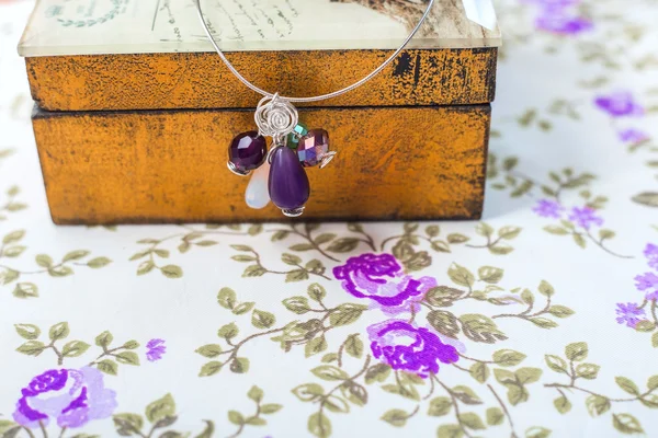 Természetes kövek, alakú gyöngyök és kristályokat lila textil alapon ezüst medál — Stock Fotó