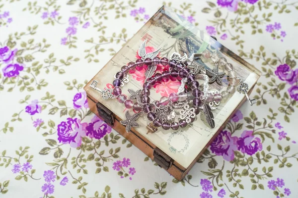 Bracciale in argento con pietre naturali, perline sagomate e cristalli su fondo tessile viola — Foto Stock