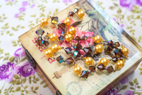 Vintage beads crystals and pearls with box and textile background — Stock Photo, Image