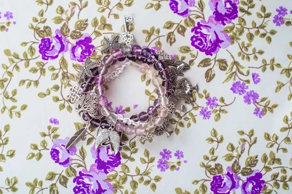 Srebrna bransoletka z kamieni naturalnych, w kształcie kulki i kryształy na tle fioletowy włókienniczych — Zdjęcie stockowe