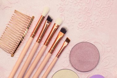 Bej arka planda makyaj fırçaları, toz ve diğer kozmetik ürünler