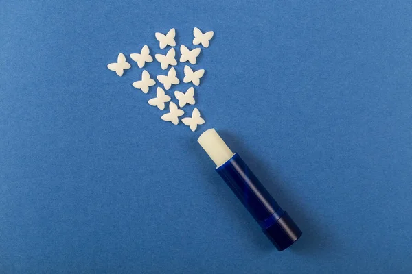 Bálsamo Labial Sobre Fondo Azul Con Mariposas Blancas Lápiz Labial — Foto de Stock