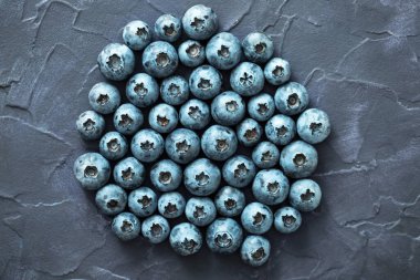 Eskimiş koyu mavi arka planda yabanmersini. Kuzey Avrupa 'nın yabani meyveleri. Antioksidan ve vitamin açısından zengin sağlıklı olgun meyveler. Üst görünüm.