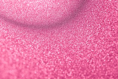 Bulanık efektli yumuşak pembe bir arka plan. Folyo pulları yakın planda parlıyor. Soyut stok dokusu