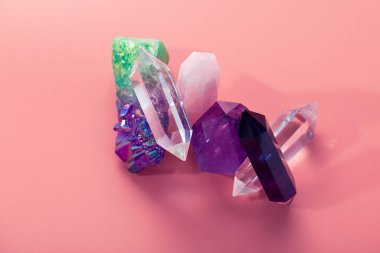 İyileştirme ve büyülü uygulamalar için çeşitli kristaller. Reiki taşları. Ametist, gül kuvars, florit, pastel pembe arka planda kaya kristali.