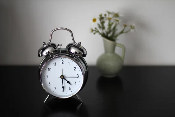 Reloj despertador está sobre la mesa —  Fotos de Stock