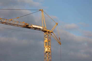 Crane, mavi gökyüzünün arka planında bir inşaat alanında.