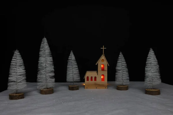 Landscape with a small church made of plywood on Christmas night.