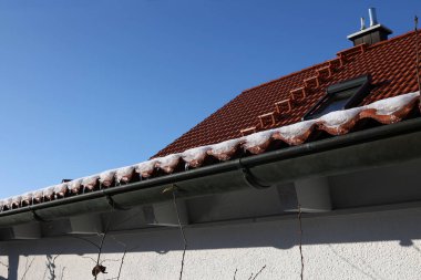 Çatıdaki kar erir ve buz saçakları oluşturur..