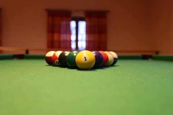 Colored pool balls on a green pool table. Billiard ball with number one.