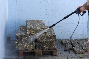 İşçi tabakları bir jet suyla yıkar..
