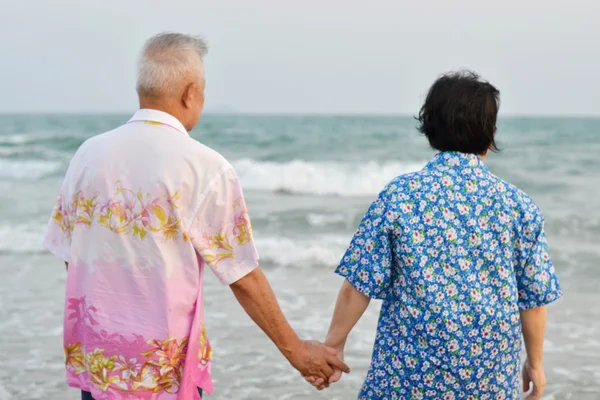 那对老夫妇在海滩上握着的手 — 图库照片