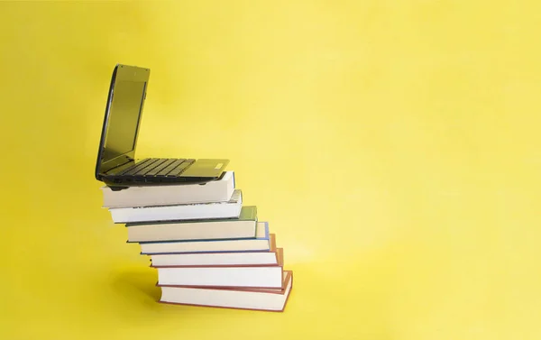 Sarı Arkaplan Üzerine Dizüstü Bilgisayar Kitap Yığını — Stok fotoğraf
