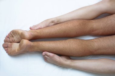 Çıplak vücutlu bir erkek ve kadın arasındaki aşk. Beyaz bir yatakta seks yapmak. Samimi arkaplan teması