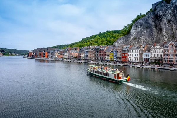 Dinant, Belçika - 19 Temmuz 2020: Tarihi Dinant kasabası. Belçika bayrağı taşıyan turist teknesi Meuse Nehri, Wallonia, Belçika