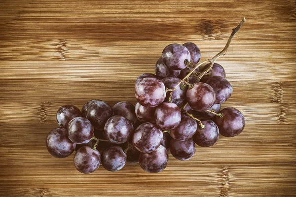 Uvas vermelhas maduras deliciosas na mesa — Fotografia de Stock