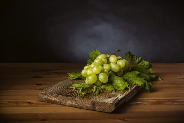 Lot de raisins verts sur table en bois marron — Photo