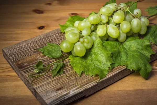 Kahverengi ahşap masa üzerinde Yeşil üzüm demet — Stok fotoğraf