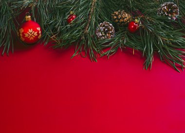 Christmas background with pine branches, pine cones and baubles.