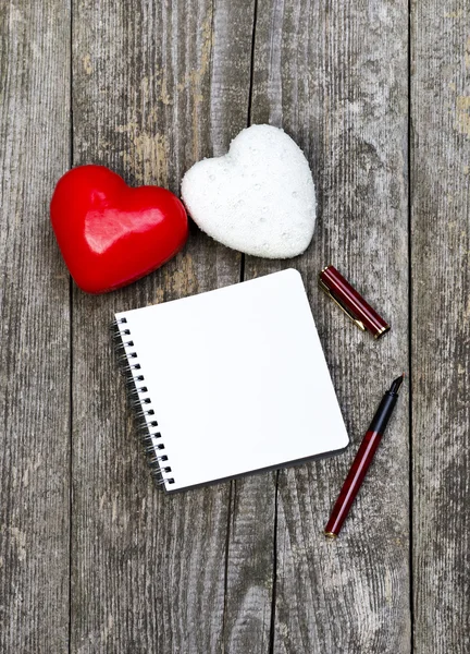 Καρδιές, κενό σημειωματάριο και στυλό — Φωτογραφία Αρχείου