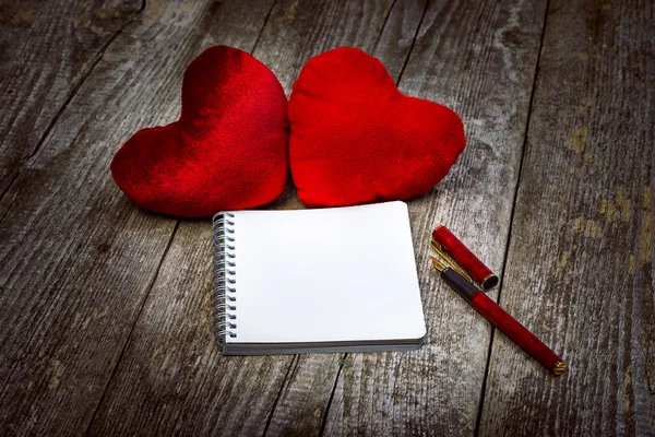 Dos corazones de terciopelo rojo y bloc de notas Fotos de stock