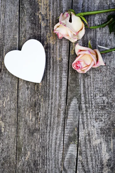 Hermosas rosas con corazón de madera blanca — Foto de Stock