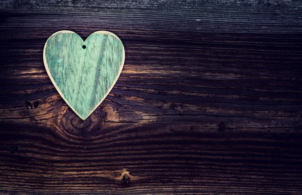 Corazón de madera verde en la mesa vieja — Foto de Stock