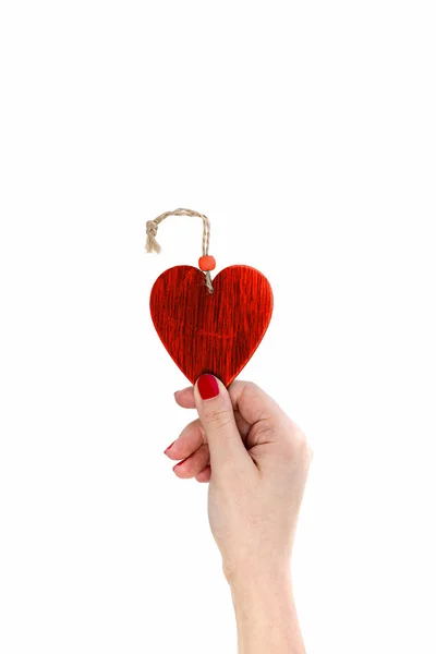 Mano femenina sosteniendo el corazón rojo de madera . — Foto de Stock