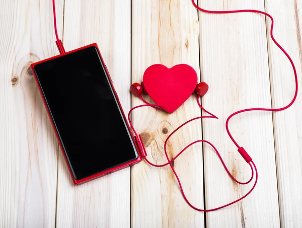 Смарт-телефон, навушники і серце. Ліцензійні Стокові Фото