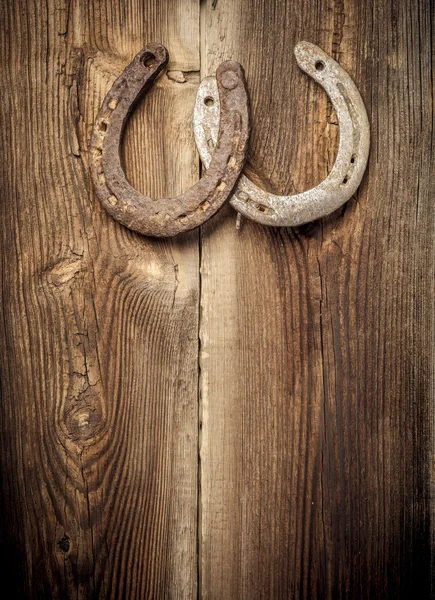 Ferri di cavallo fortunati sulla vecchia parete — Foto Stock