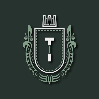 T. Heraldik harfinin birinci sınıf monogramı çiçek süsü ve taç ile çevrili bir kalkan şeklinde..