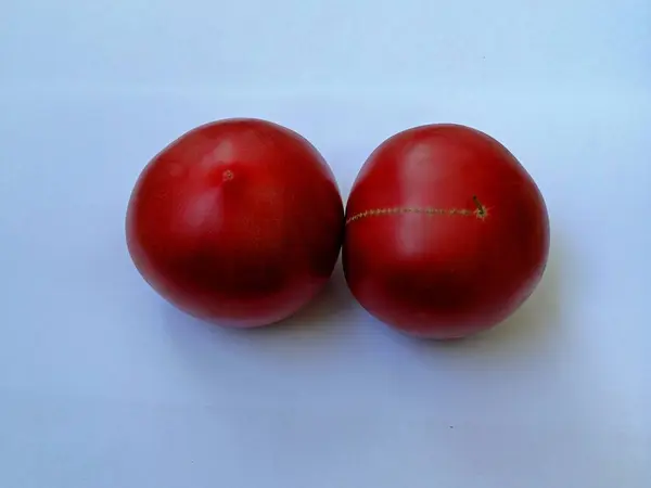Mavi arka planda lezzetli kırmızı domatesler