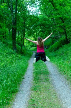 Kadın ormanda zıplıyor, dinleniyor.