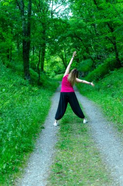 Kadın ormanda zıplıyor, dinleniyor.