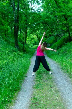 Kadın ormanda zıplıyor, dinleniyor.