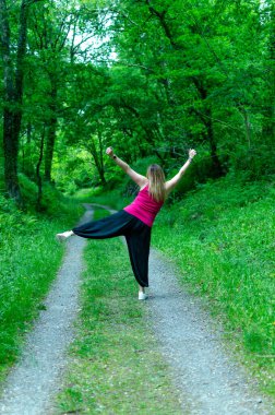 Kadın ormanda zıplıyor, dinleniyor.