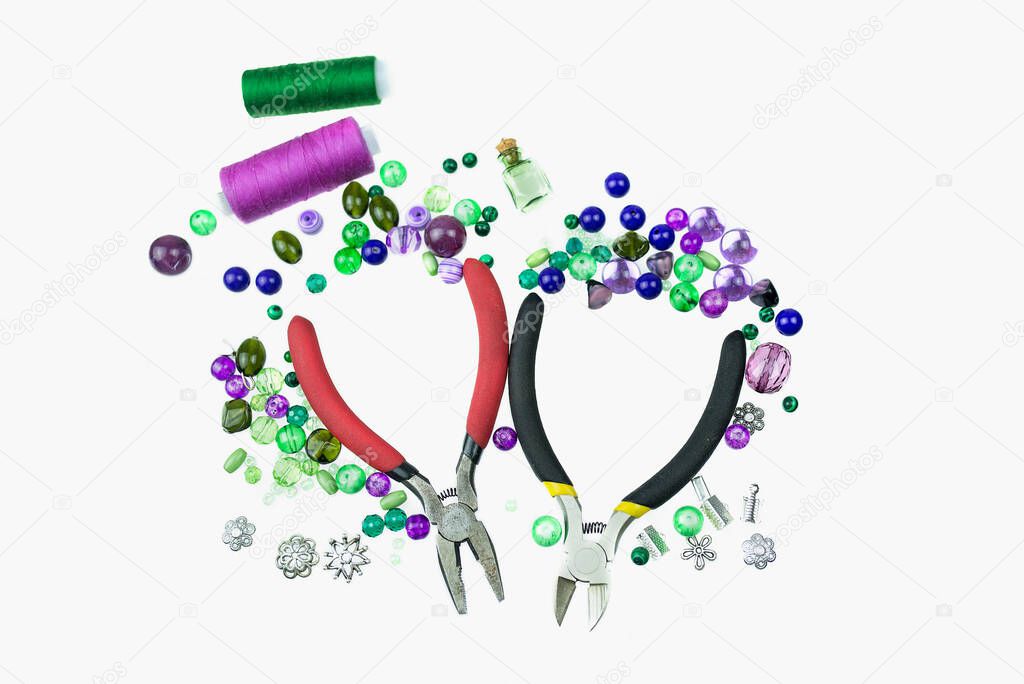 Pliers, nippers, different types of beads, sewing threads and other jewellery suppliersa are isolated on a white background. Creative hobby of sewing and jewelry making concept.