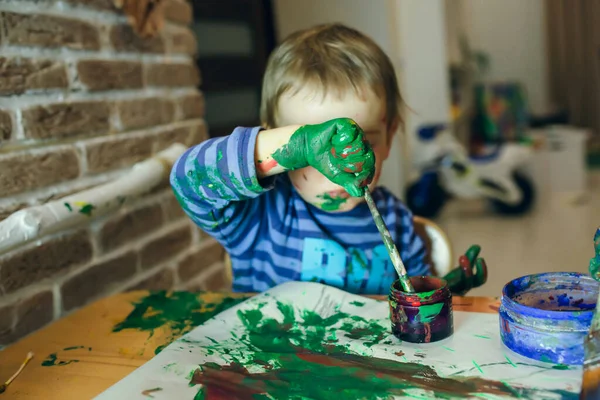 Мальчик Рисует Руками Щёткой Столом Дома Испачканной Рукой Лице Идея — стоковое фото