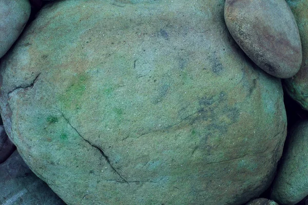 布满皱纹和斑点的大块头长毛的河石表面 周围都是较小的石头 有纹理的天然石头背景 — 图库照片
