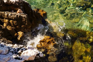 Kayalara çarpan deniz sörfü, temiz su, tuzla kaplı kayalar.
