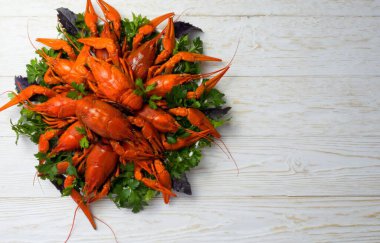 Taze kaynamış kırmızı kerevit tabakta parlak bir masada yatıyor.