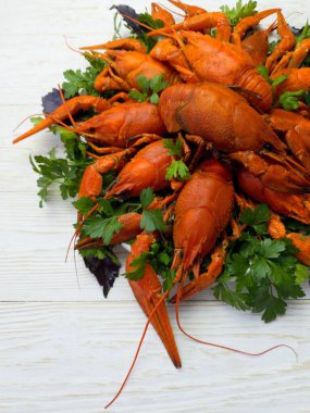 Taze kaynamış kırmızı kerevit tabakta parlak bir masada yatıyor.