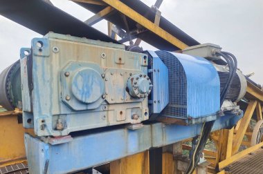 Mekanik bileşenlerini ve verimli malzeme işleme sistemini vurgulayan keskin detaylarla yakalanmış mavi bir endüstriyel taşıyıcı makine. Madencilik, imalat ve lojistik için ideal,