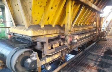 Besleme sistemindeki kömür boşaltma alanının detaylı bir görüntüsü, işlenmemiş kömürün işlenmeye hazır olduğu engebeli yapıyı gösteriyor. Görüntü sanayi operasyonları ve ağır ekipmanları vurguluyor