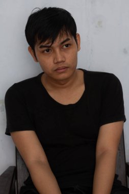 Düşünceli ve sakin bir ifadeyle, arka planda siyah bir gömlek giyen bir adamın portresi. Tarafsız ton ve doğal ışıklandırma bu resmi temalar için uygun hale getirir 