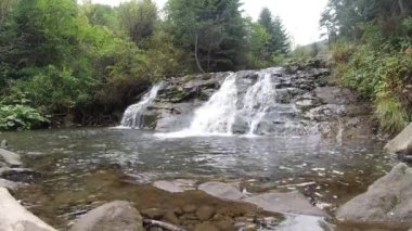 Sonbahar ormanlarının arasında bir dağ şelalesi