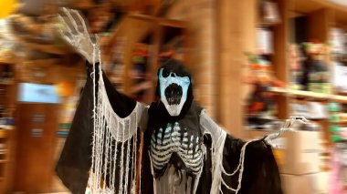 Kara pelerinle saldırmak için iskelet.