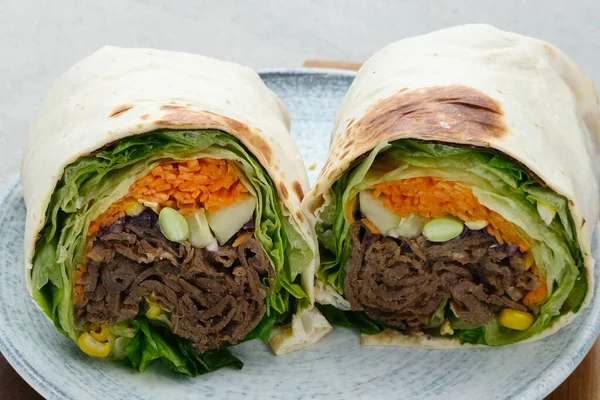 Salad Wrap. Tortilla wraps with beef teriyaki and fresh vegetables. Close up and selective focus image.