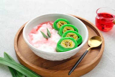 Es Pisang Ijo, Güney Sulawesi, Endonezya 'dan geleneksel tatlı, muz buğday unu, pirinç unu ve hindistan cevizi sütü karışımı ile yapılır. Püre ve şurupla servis edilir..