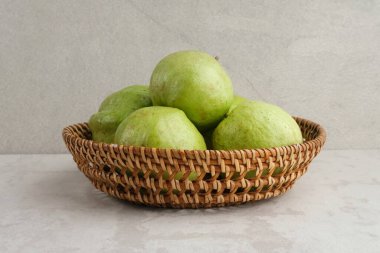 Kristal Guava (Psidium guajava) veya Jambu Kristal, gri arka planda rattan sepeti içinde servis edilir. Boşluğu kopyala.